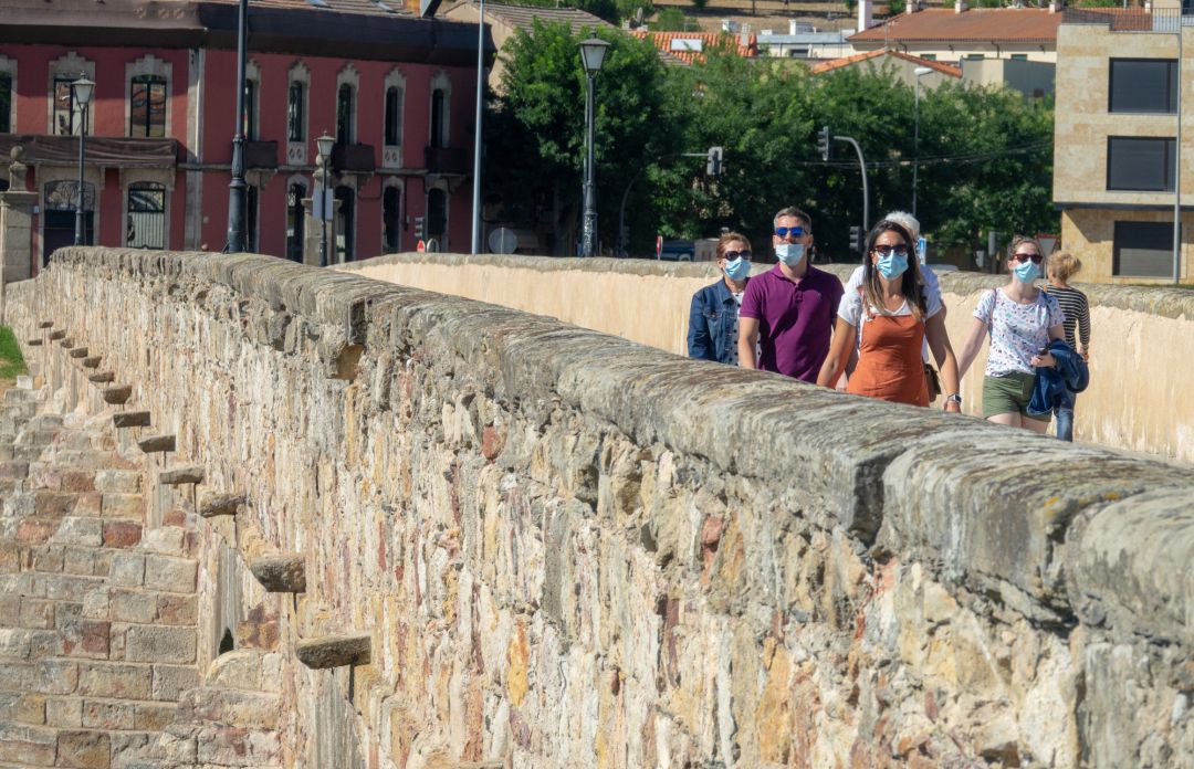 Imagen de turistas, pocos, paseando por el Puente Romano. Imagen de turistas, pocos, paseando por el Puente Romano.