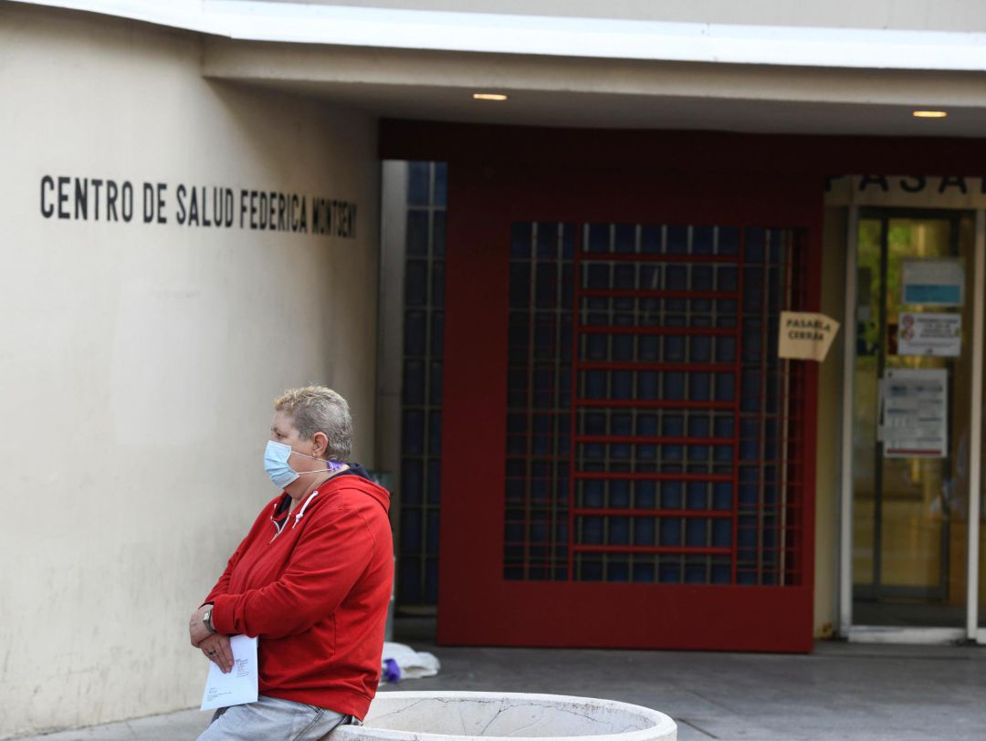 Una mujer espera en el exterior del centro de salud Federica Montseny en el distrito de Puente de Vallecas en Madrid. Una mujer espera en el exterior del centro de salud Federica Montseny en el distrito de Puente de Vallecas en Madrid.