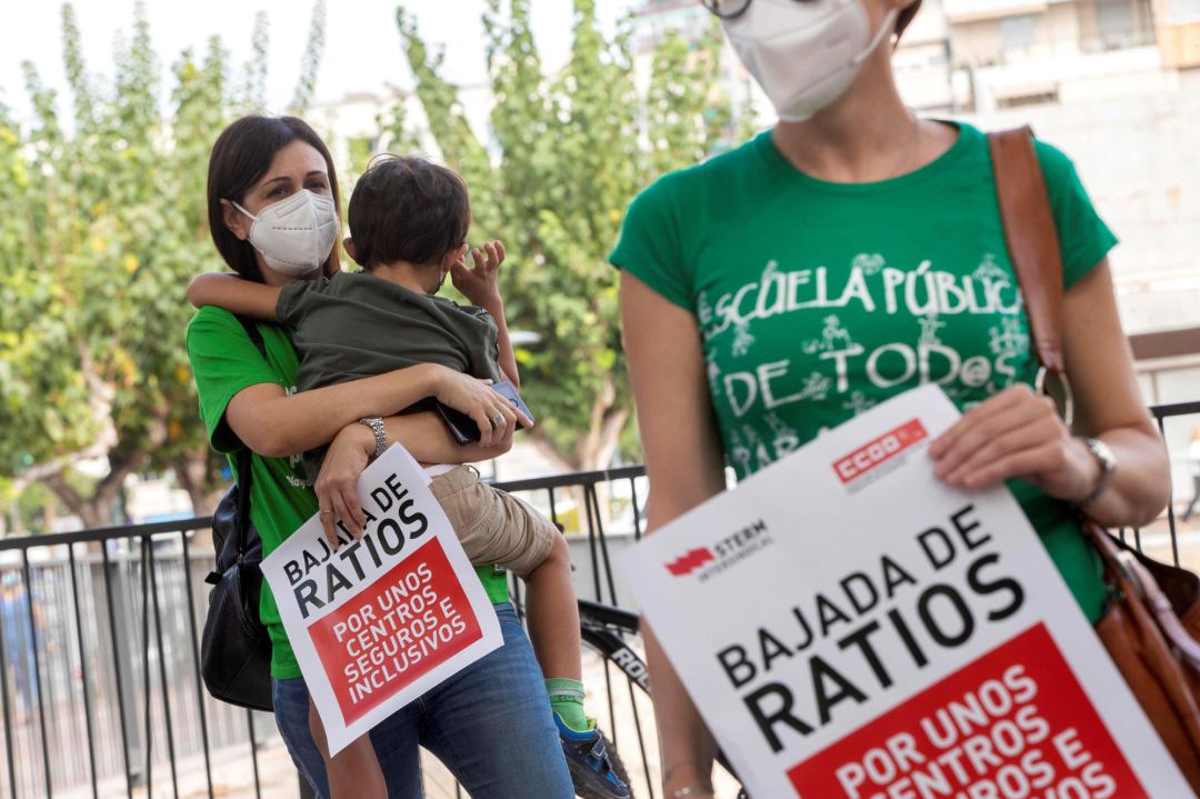 Una profesora con su hijo en brazos este miércoles durante la manifestación convocada por los docentes de CCOO y STERM, para reivindicar una vuelta a las aulas segura, diálogo con la comunidad educativa, que califican de inexistente, y un aumento de las plantillas que permita reducir las ratios y evitar la semipresencialidad por el coronavirus Una profesora con su hijo en brazos este miércoles durante la manifestación convocada por los docentes de CCOO y STERM, para reivindicar una vuelta a las aulas segura, diálogo con la comunidad educativa, que califican de inexistente, y un aumento de las plantillas que permita reducir las ratios y evitar la semipresencialidad por el coronavirus