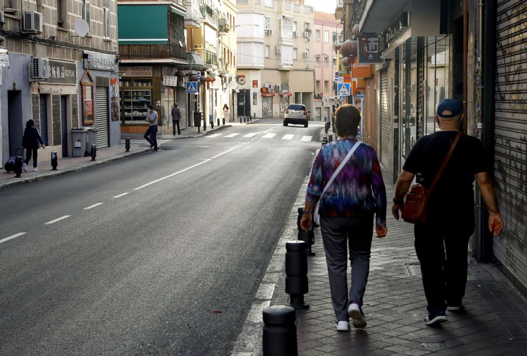 Una pareja camina por una calle de Usera, uno de los barrios afectados por las restricciones sanitarias en Madrid Una pareja camina por una calle de Usera, uno de los barrios afectados por las restricciones sanitarias en Madrid