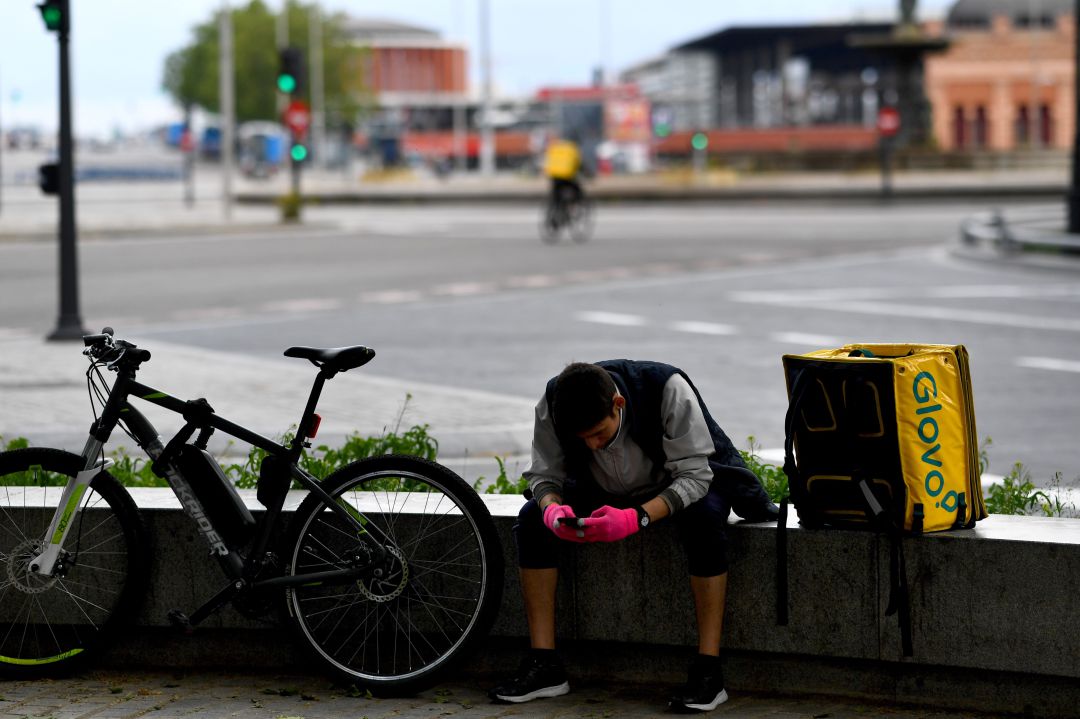 Un trabajador de Glovo, frente a la estación de Atocha de Madrid. Un trabajador de Glovo, frente a la estación de Atocha de Madrid.