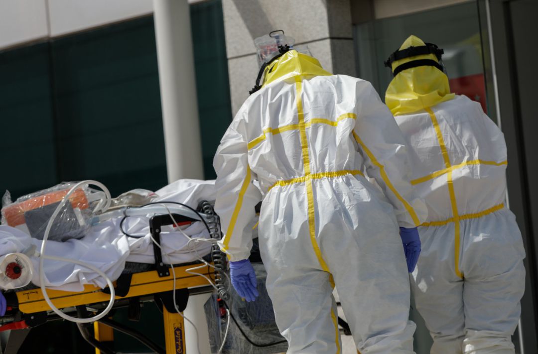 Varios sanitarios trasladan a un paciente desde el interior de una unidad móvil Varios sanitarios trasladan a un paciente desde el interior de una unidad móvil