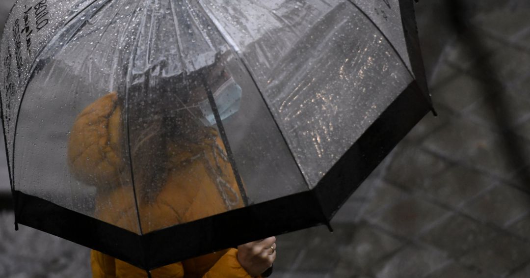 Una persona camina bajo la lluvia protegida con un paraguas en Madrid. Una persona camina bajo la lluvia protegida con un paraguas en Madrid.