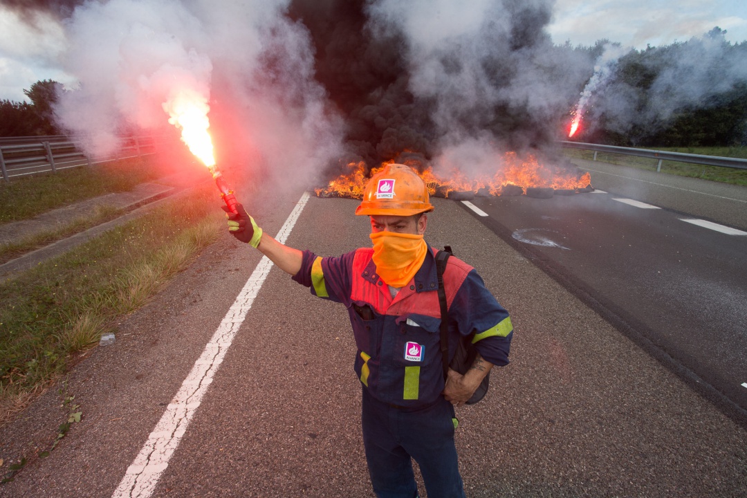 Un trabajador de Alcoa San Cibrao enciende una bengala durante una manifestación en la que han cortado la Autopista A6 con la quema de neumáticos, en Outeiro de Rei, Lugo. Un trabajador de Alcoa San Cibrao enciende una bengala durante una manifestación en la que han cortado la Autopista A6 con la quema de neumáticos, en Outeiro de Rei, Lugo.