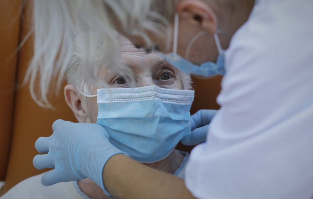 Colocando la mascarilla a una anciana Colocando la mascarilla a una anciana