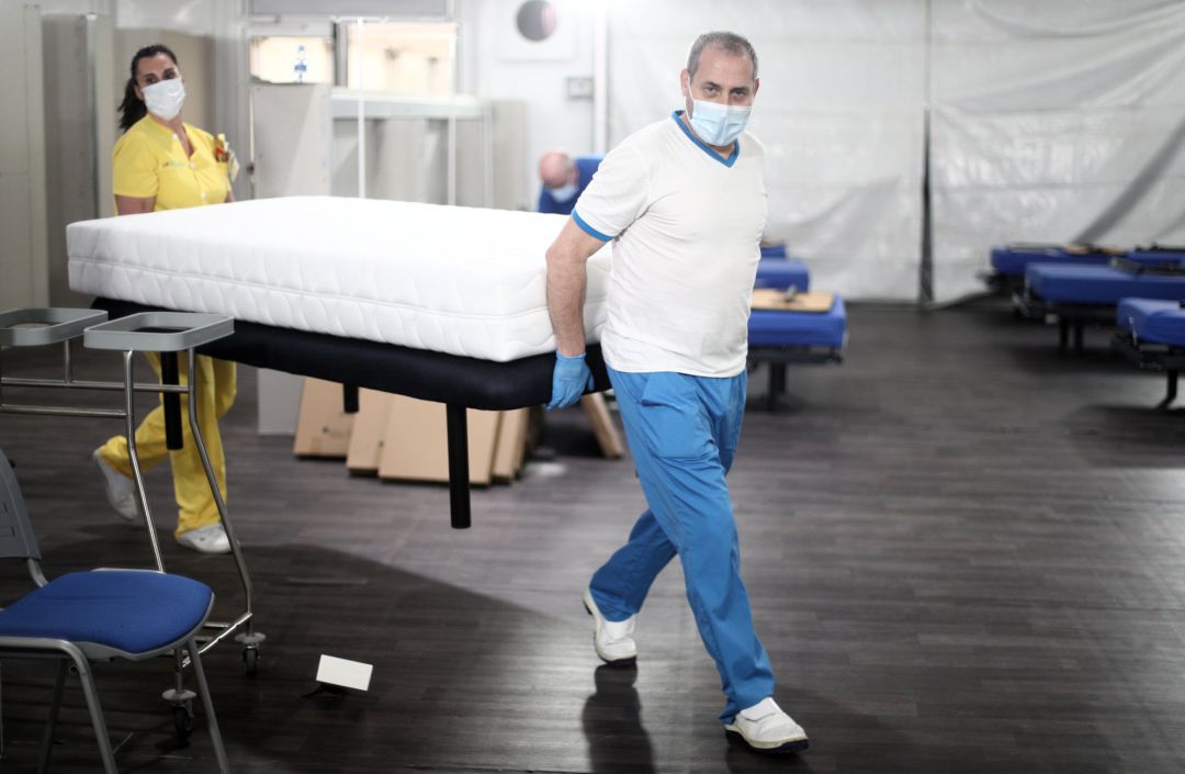 Dos profesionales sanitarios preparan camas para enfermos de coronavirus. Dos profesionales sanitarios preparan camas para enfermos de coronavirus.