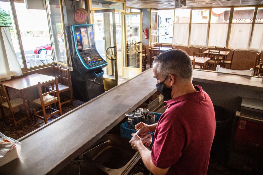 Un camarero seca varios vasos en un bar Un camarero seca varios vasos en un bar