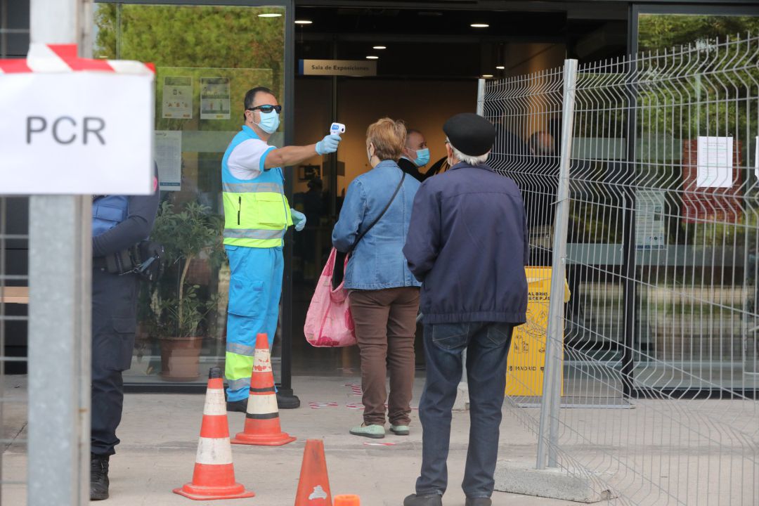 Un trabajador toma la temperatura a los vecinos antes de entrar al Centro Cultural Lope de Vega. Un trabajador toma la temperatura a los vecinos antes de entrar al Centro Cultural Lope de Vega.
