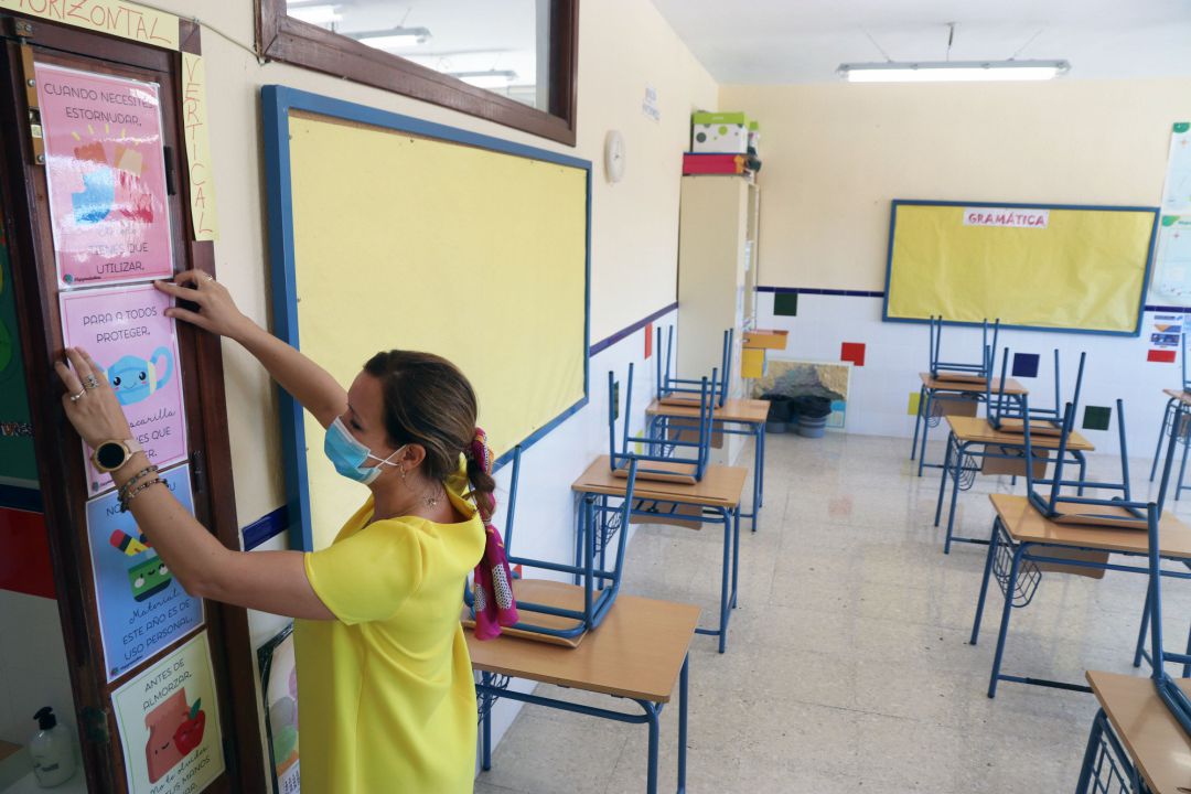 Una profesora coloca carteles de medidas preventivas ante el COVID-19 en el aula antes del inicio del curso escolar en un colegio público Una profesora coloca carteles de medidas preventivas ante el COVID-19 en el aula antes del inicio del curso escolar en un colegio público