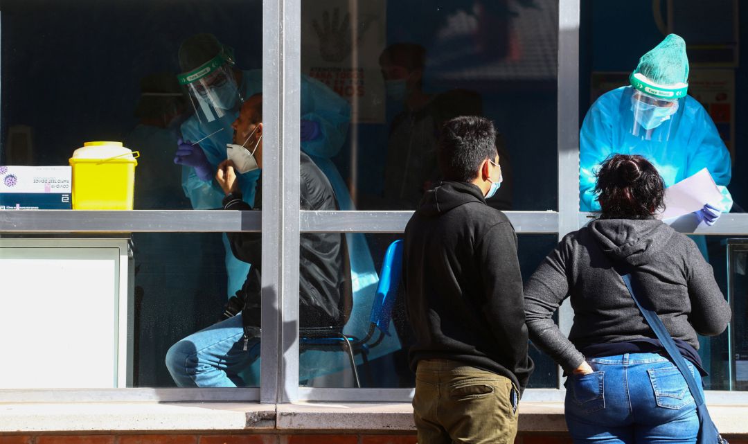Un médico realiza una prueba PCR a un paciente Un médico realiza una prueba PCR a un paciente