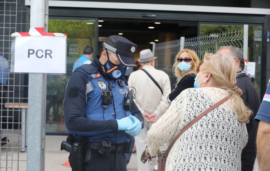 Un policía municipal pide la documentación a una mujer antes de entrar al Centro Cultural Lope de Vega, en la Zona Básica de Salud (ZBS) de Puente de Vallecas. Un policía municipal pide la documentación a una mujer antes de entrar al Centro Cultural Lope de Vega, en la Zona Básica de Salud (ZBS) de Puente de Vallecas.