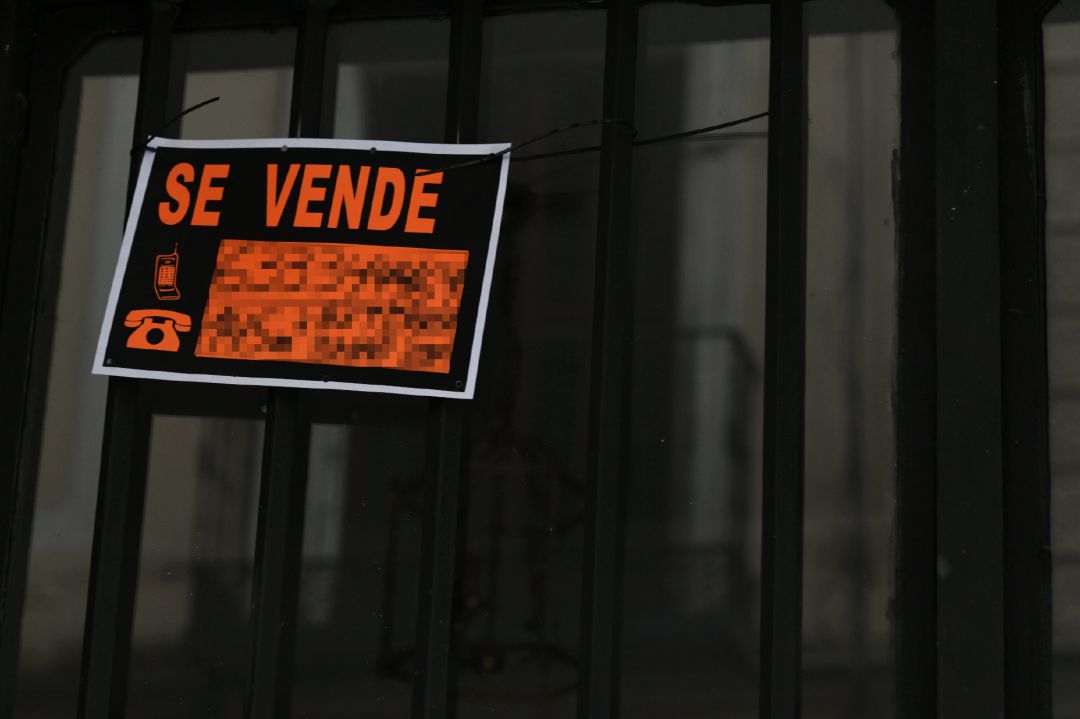 Cartel colgado en un edificio que indica que el inmueble está en venta Cartel colgado en un edificio que indica que el inmueble está en venta
