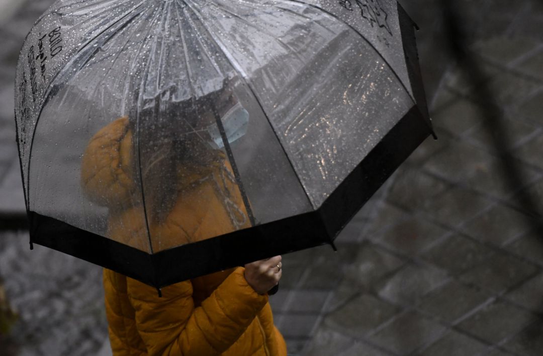 Una persona camina bajo la lluvia Una persona camina bajo la lluvia