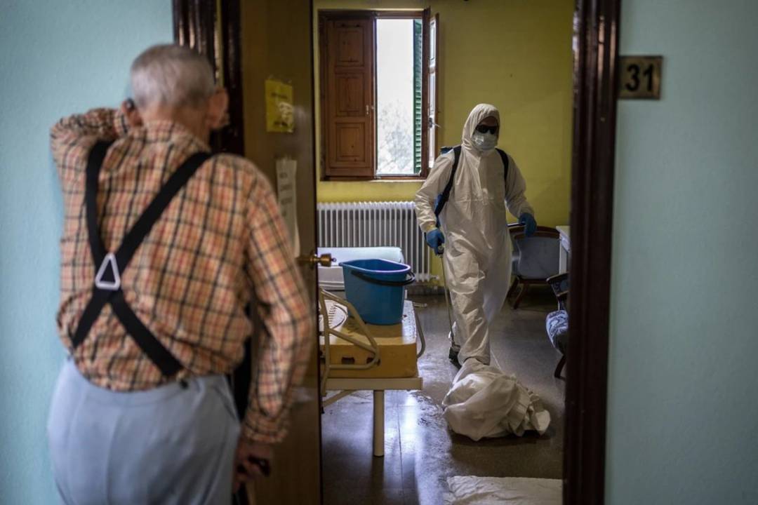 Un anciano contempla en una residencia la actuación del personal sanitario. Un anciano contempla en una residencia la actuación del personal sanitario.