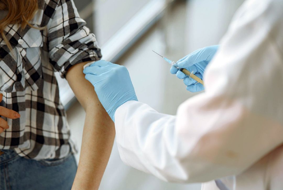 Un sanitario poniendo una vacuna de la gripe. Un sanitario poniendo una vacuna de la gripe.