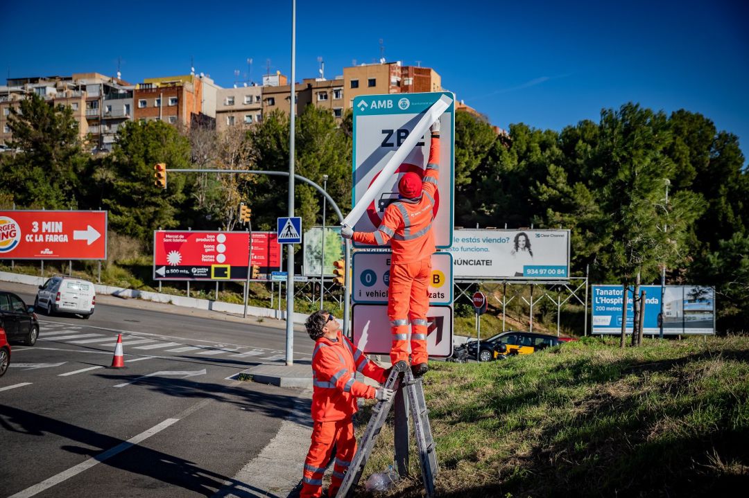 Operaris instal·lant una senyal de Zona de Baixes Emissions Operaris instal·lant una senyal de Zona de Baixes Emissions