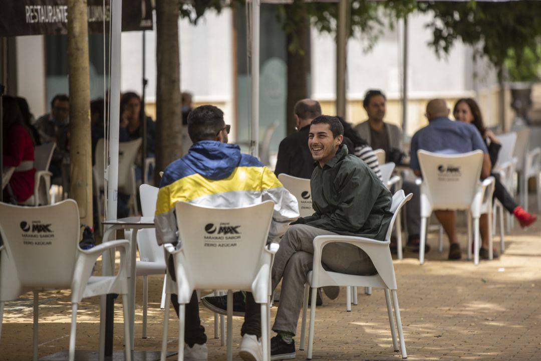 Personas consumiendo en los veladores de un bar (imagen de archivo) Personas consumiendo en los veladores de un bar (imagen de archivo)