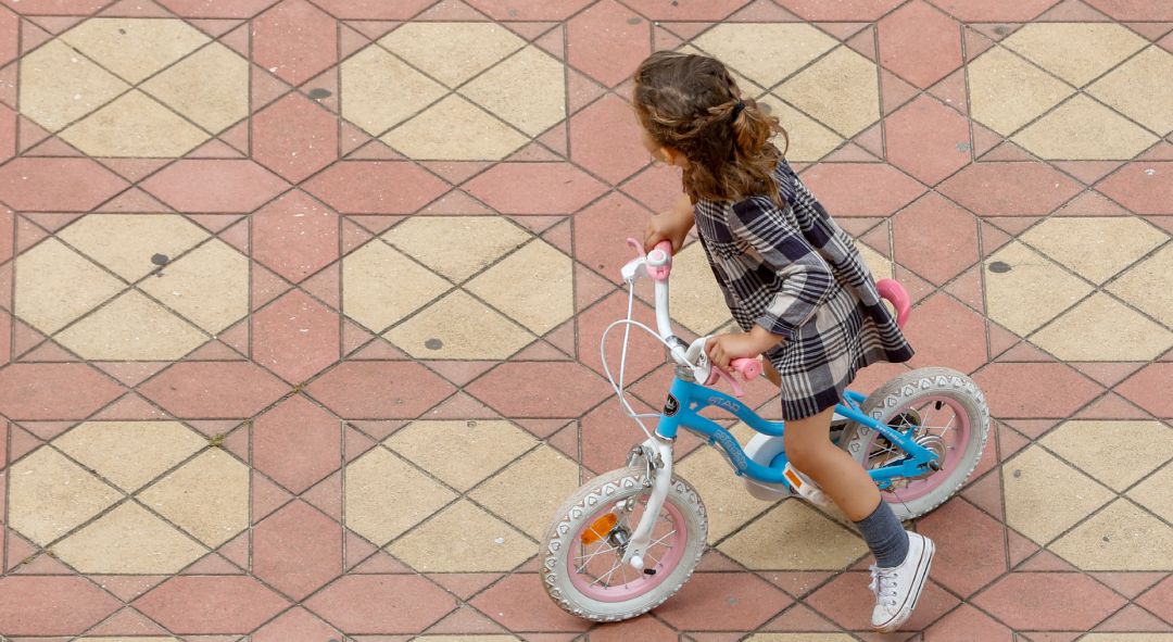 Una niña jugando con su bicicleta. Una niña jugando con su bicicleta.