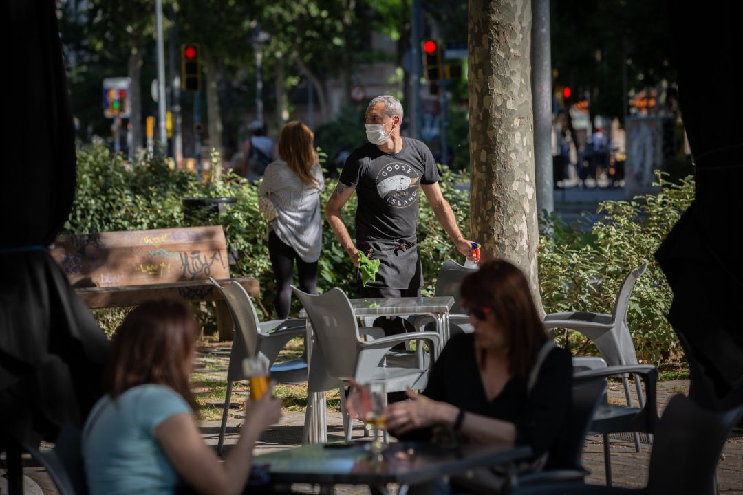 Varias personas disfrutan en la terraza de un bar en Barcelona Varias personas disfrutan en la terraza de un bar en Barcelona