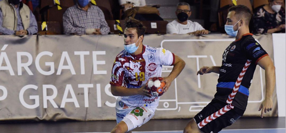El jugador del Abanca Ademar Gonzalo Pérez (i) lanza ante la defensa del Sinfín Liberbank durante el partido de la octava jornada de la Liga Sacyr ASOBAL disputado hoy en el palacio municipal de deportes de León. Los jugadores de ambos equipos tuvieron que disputar el encuentro provistos de mascarilla debido a las medidas sanitarias impuestas por la Junta de Castilla y León para frena la expansión de la pandemia de la cpvid-19. El jugador del Abanca Ademar Gonzalo Pérez (i) lanza ante la defensa del Sinfín Liberbank durante el partido de la octava jornada de la Liga Sacyr ASOBAL disputado hoy en el palacio municipal de deportes de León. Los jugadores de ambos equipos tuvieron que disputar el encuentro provistos de mascarilla debido a las medidas sanitarias impuestas por la Junta de Castilla y León para frena la expansión de la pandemia de la cpvid-19.