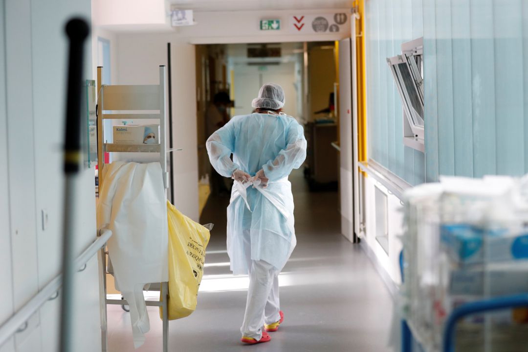 Una médico poniéndose el EPI para comenzar a trabajar Una médico poniéndose el EPI para comenzar a trabajar