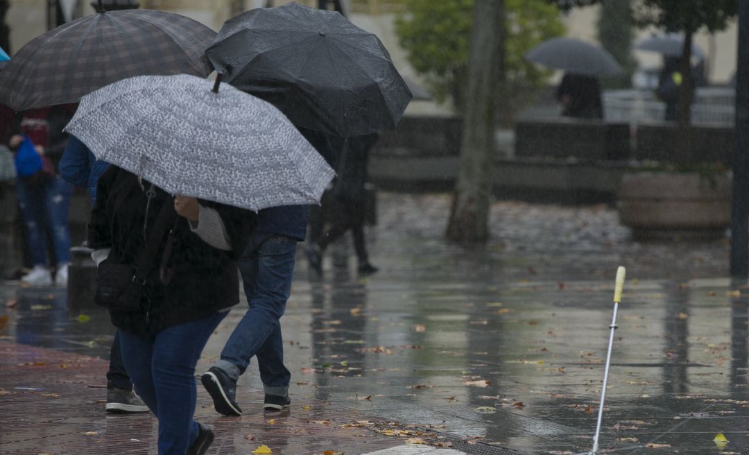 Personas se protegen de la lluvia durante una borrasca. Personas se protegen de la lluvia durante una borrasca.
