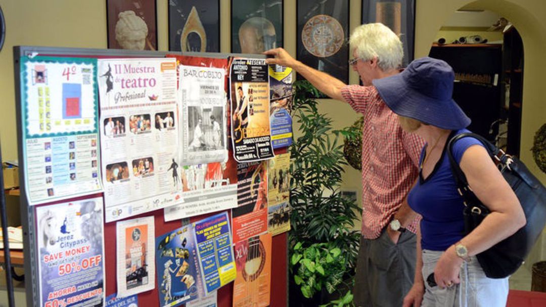 Dos turistas consultan la oferta cultural Dos turistas consultan la oferta cultural