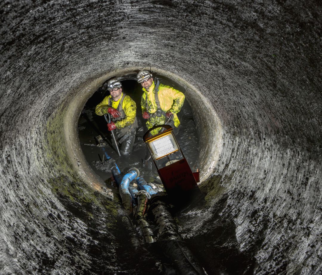Operarios en un túnel de aguas residuales Operarios en un túnel de aguas residuales