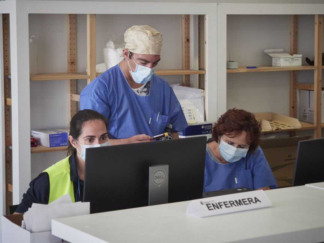 Trabajadores sanitarios protegidos atienden a los pacientes que acuden para realizarse una extracción de muestras en el recinto ferial REFENA de Pamplona Trabajadores sanitarios protegidos atienden a los pacientes que acuden para realizarse una extracción de muestras en el recinto ferial REFENA de Pamplona