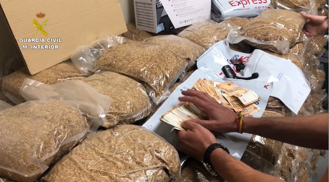Imagen del vídeo distribuido por la Guardia Civil en el que se observa los paquetes de picadura de tabaco y el dinero en efectivo intervenido en una nave de Valdemoro. Imagen del vídeo distribuido por la Guardia Civil en el que se observa los paquetes de picadura de tabaco y el dinero en efectivo intervenido en una nave de Valdemoro.