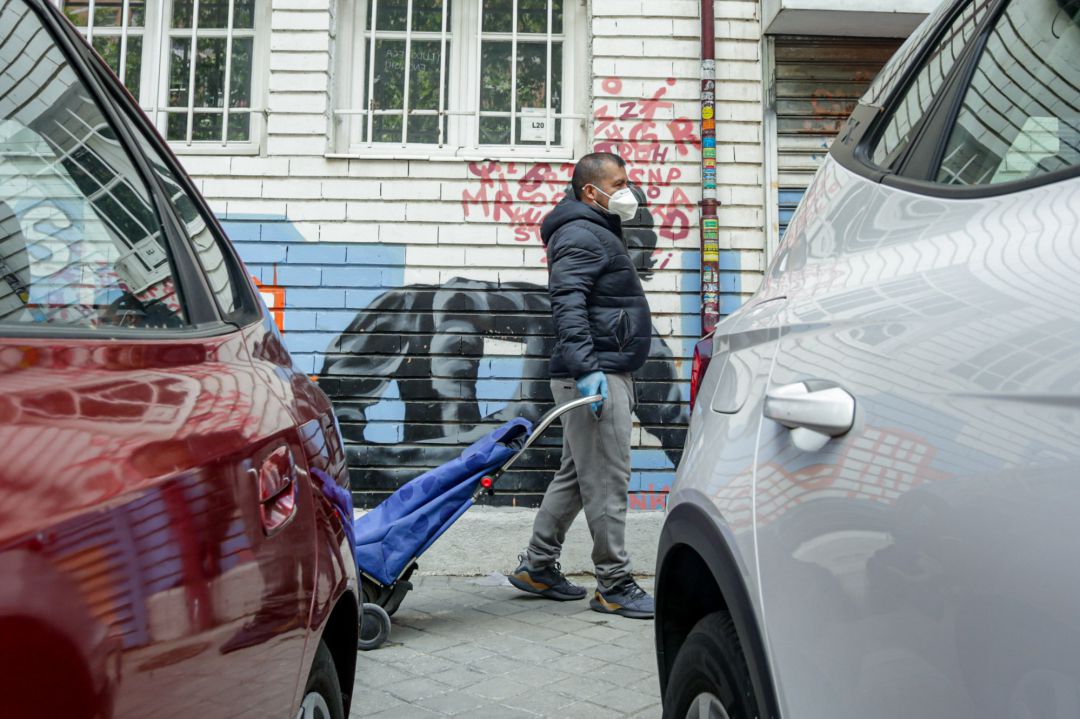 Vecinos realizan una cola para recoger bolsas de alimentos Vecinos realizan una cola para recoger bolsas de alimentos