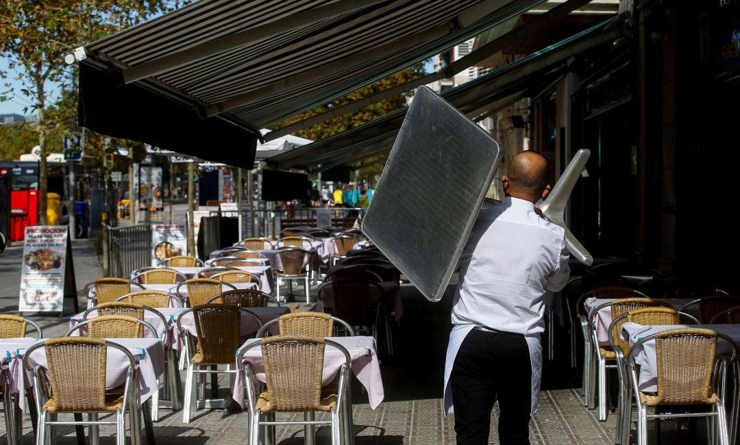 Un camarero recoge una mesa de una terraza de un restaurante del barrio de la Barceloneta de Barcelona, este jueves, a la espera de que mañana entre en vigor el cierre de bares y restaurantes durante 15 días y las nuevas restricciones de aforo en centros comerciales, comercios, gimnasios, teatros y cines que ha aprobado el gobierno catalán para intentar contener los contagios de coronavirus. Un camarero recoge una mesa de una terraza de un restaurante del barrio de la Barceloneta de Barcelona, este jueves, a la espera de que mañana entre en vigor el cierre de bares y restaurantes durante 15 días y las nuevas restricciones de aforo en centros comerciales, comercios, gimnasios, teatros y cines que ha aprobado el gobierno catalán para intentar contener los contagios de coronavirus.