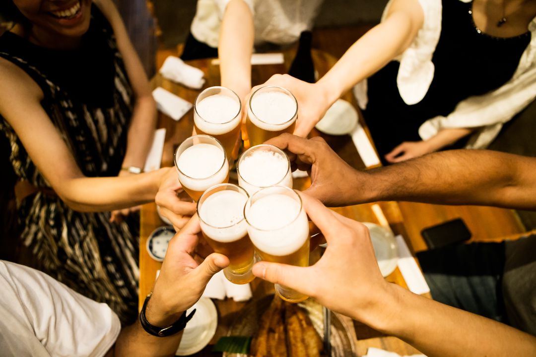 Varias personas brindan con cerveza. Varias personas brindan con cerveza.