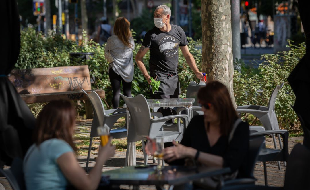 Varias personas disfrutan en la terraza de un bar en Barcelona Varias personas disfrutan en la terraza de un bar en Barcelona