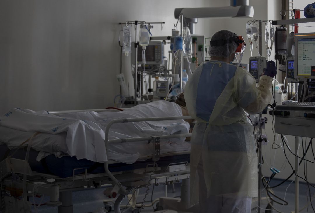 Un sanitario atiende a un paciente en la Unidad de Cuidados Intensivos Un sanitario atiende a un paciente en la Unidad de Cuidados Intensivos