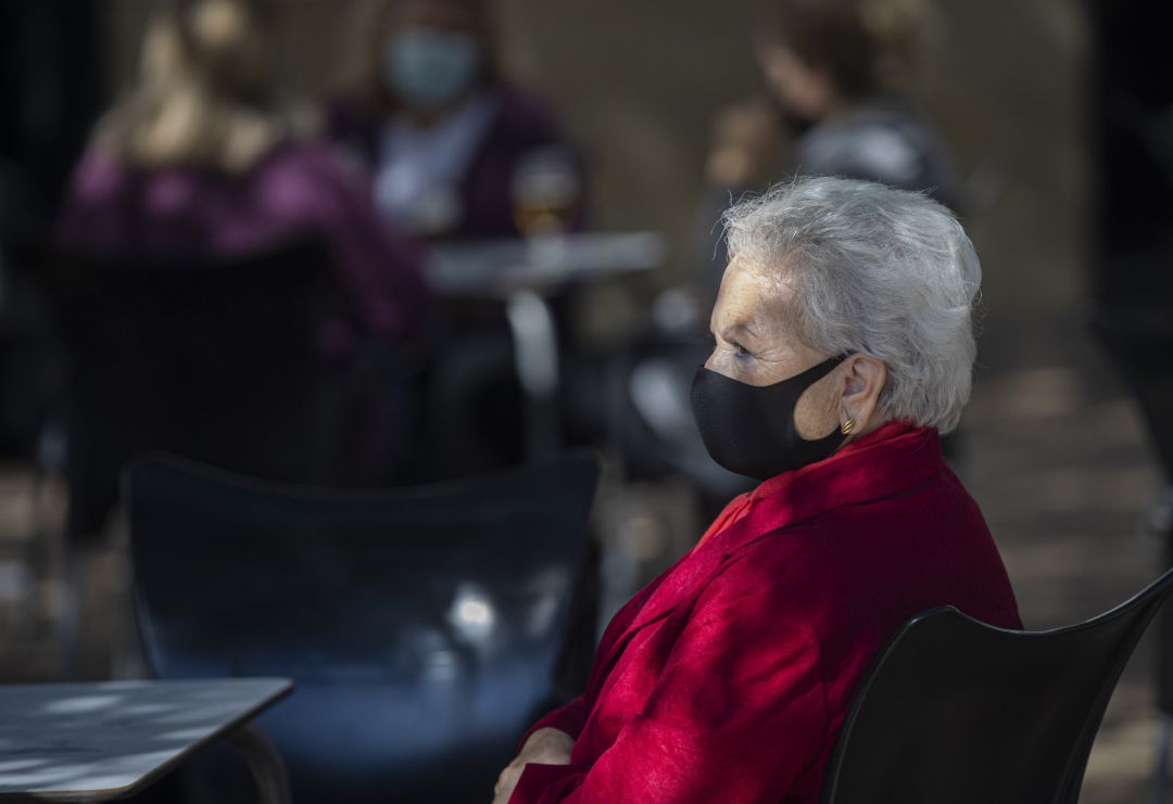 Una mujer mayor con mascarilla en la terraza de un bar, en una imagen de archivo Una mujer mayor con mascarilla en la terraza de un bar, en una imagen de archivo