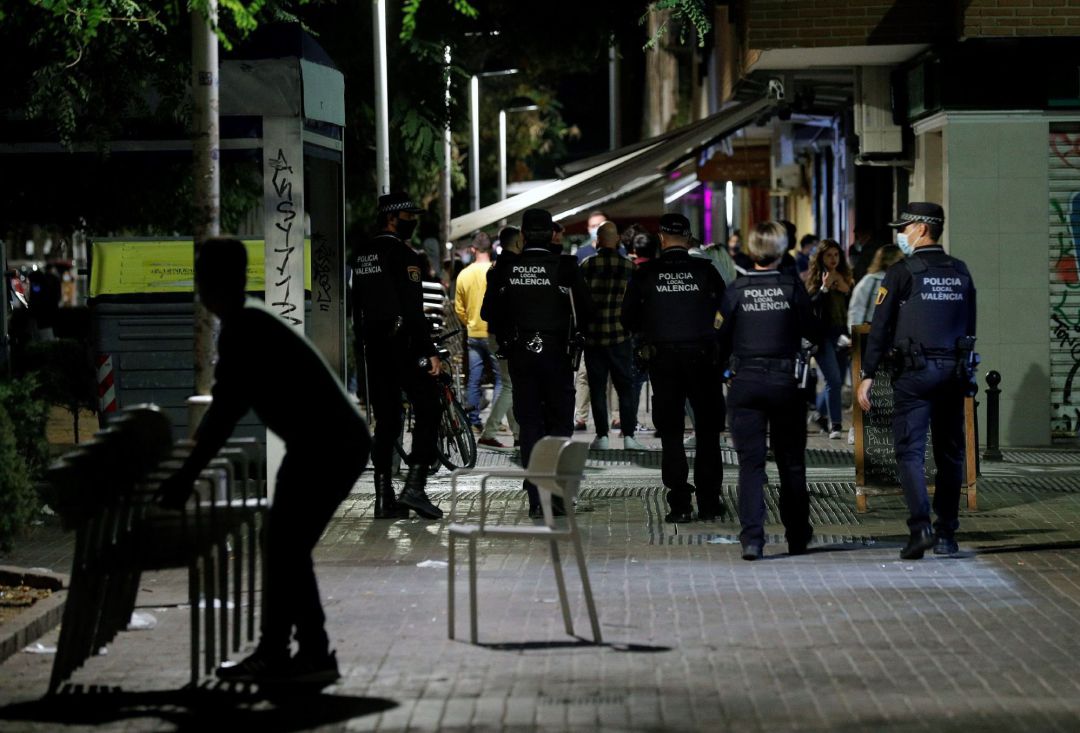 Agentes de la Policía Local de Valencia recorren las terrazas de una conocida zona de ocio de la ciudad vigilando que se cumplen los horarios de cierre y las medidas ante la covid-19 a poco minutos de la entrada en vigor del toque de queda. Agentes de la Policía Local de Valencia recorren las terrazas de una conocida zona de ocio de la ciudad vigilando que se cumplen los horarios de cierre y las medidas ante la covid-19 a poco minutos de la entrada en vigor del toque de queda.