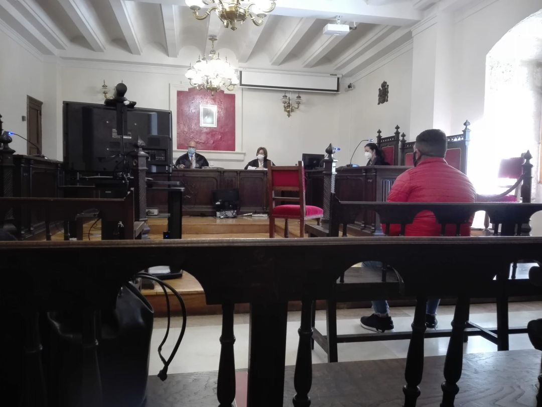 El acusado, con cazadora roja, mientras la víctima declaraba por videoconferencia El acusado, con cazadora roja, mientras la víctima declaraba por videoconferencia