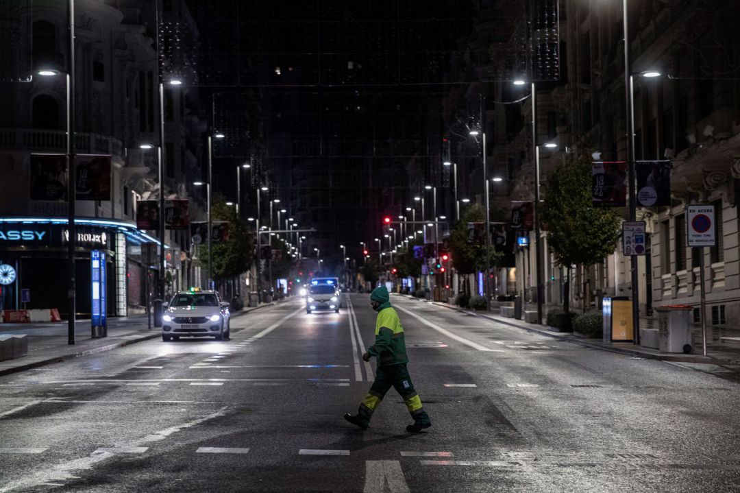 Un operario de los servicios de limpieza cruza la Gran Vía en la primera jornada de toque de queda en Madrid. Un operario de los servicios de limpieza cruza la Gran Vía en la primera jornada de toque de queda en Madrid.