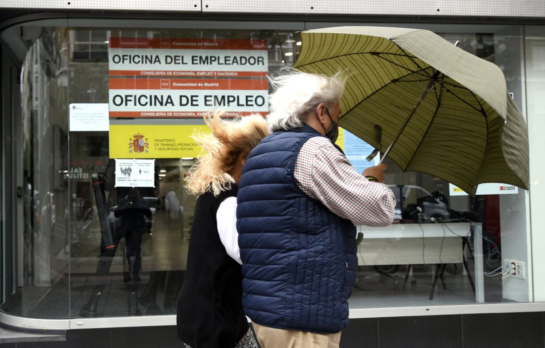 Una pareja pasa al lado de una Oficina de Empleo en Madrid Una pareja pasa al lado de una Oficina de Empleo en Madrid
