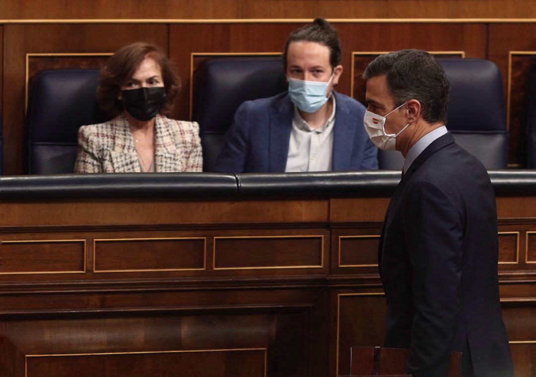 El presidente del Gobierno, Pedro Sánchez, pasa por delante la vicepresidenta primera del Gobierno, Carmen Calvo, y el vicepresidente segundo del Gobierno, Pablo Iglesias, durante una sesión de control El presidente del Gobierno, Pedro Sánchez, pasa por delante la vicepresidenta primera del Gobierno, Carmen Calvo, y el vicepresidente segundo del Gobierno, Pablo Iglesias, durante una sesión de control