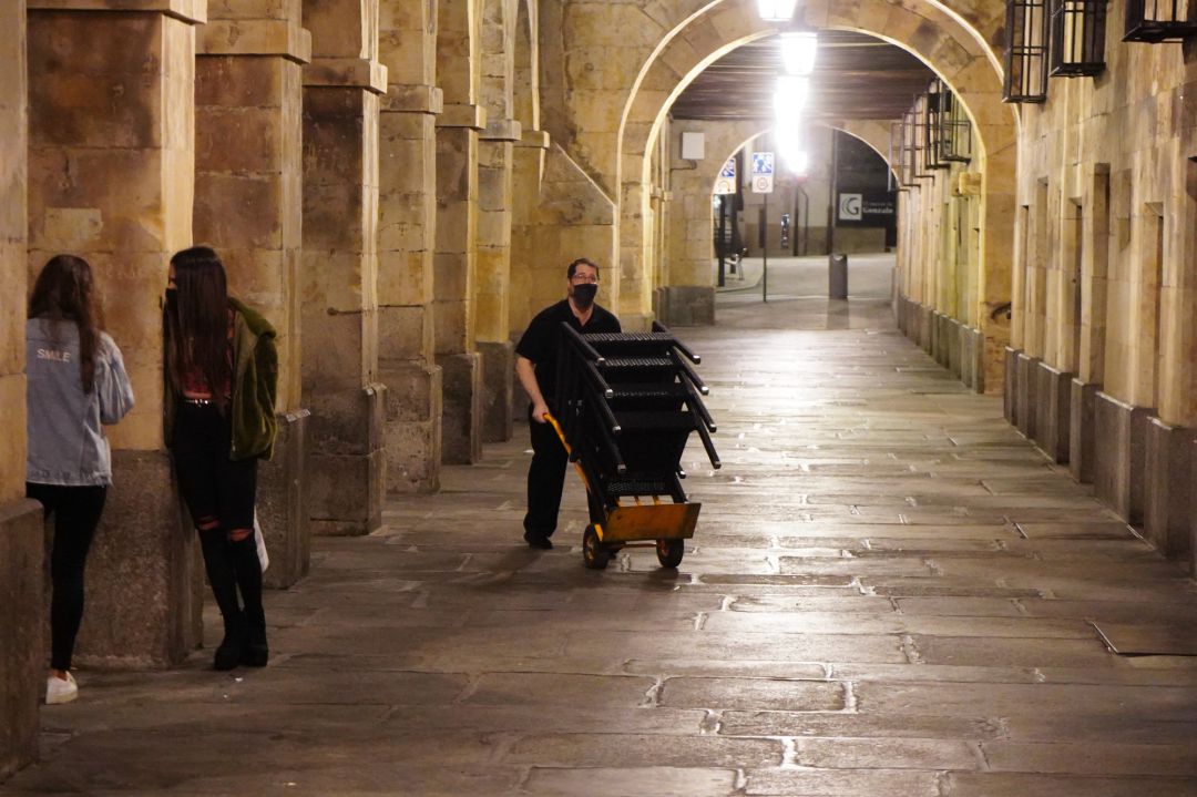 Un trabajador del entorno de la Plaza Mayor cierra su establecimiento ante el toque de queda. Un trabajador del entorno de la Plaza Mayor cierra su establecimiento ante el toque de queda.