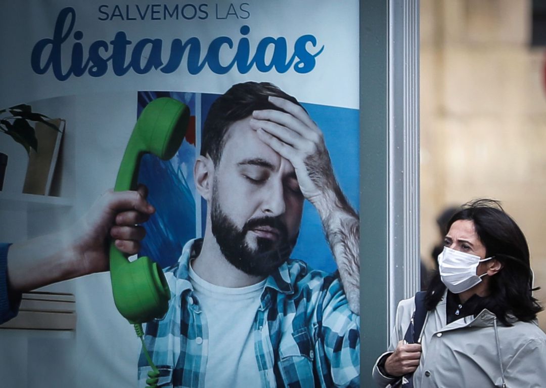 Una mujer pasa junto a un panel publicitario este lunes en San Sebastián. Una mujer pasa junto a un panel publicitario este lunes en San Sebastián.
