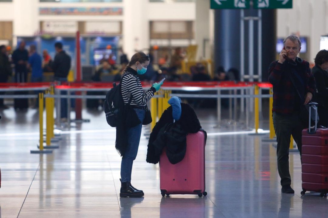 Una turista con mascarilla y guantes en el aeropuerto de Málaga Una turista con mascarilla y guantes en el aeropuerto de Málaga