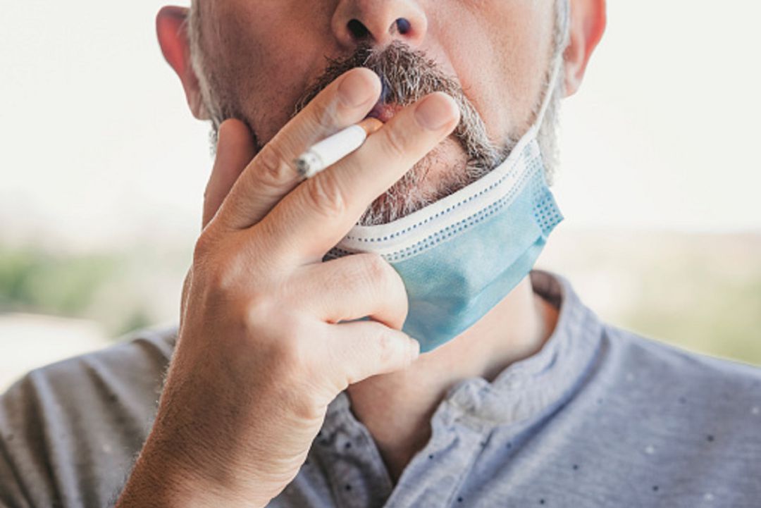 Hombre fumando con mascarilla Hombre fumando con mascarilla