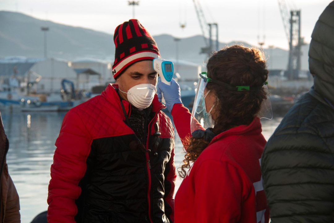 Voluntaria de Cruz Roja toma la temperatura a uno de los inmigrantes trasladados al Puerto de Motril Voluntaria de Cruz Roja toma la temperatura a uno de los inmigrantes trasladados al Puerto de Motril