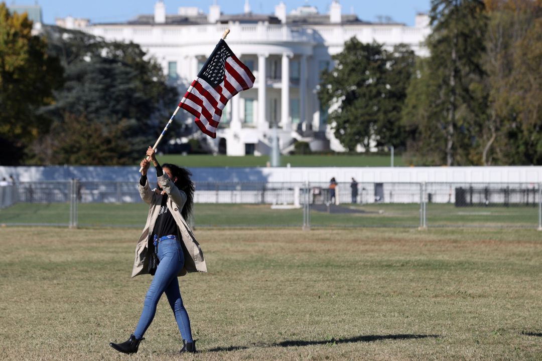 Una mujer, con la bandera de EEUU frente a la Casa Blanca tras las elecciones Una mujer, con la bandera de EEUU frente a la Casa Blanca tras las elecciones