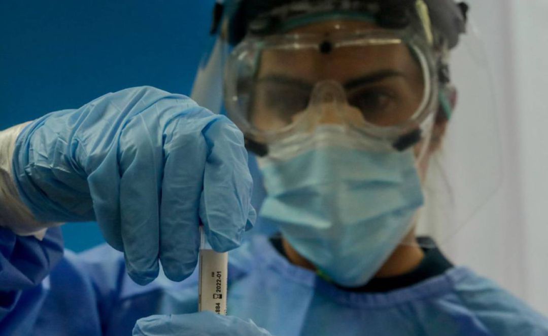 Una trabajadora sanitaria sostiene una probeta con una prueba PCR, en una imagen de archivo Una trabajadora sanitaria sostiene una probeta con una prueba PCR, en una imagen de archivo