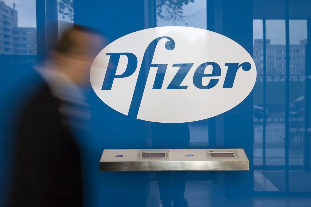 Imagen de archivo de un hombre pasando frente al logo de Pfizer Imagen de archivo de un hombre pasando frente al logo de Pfizer