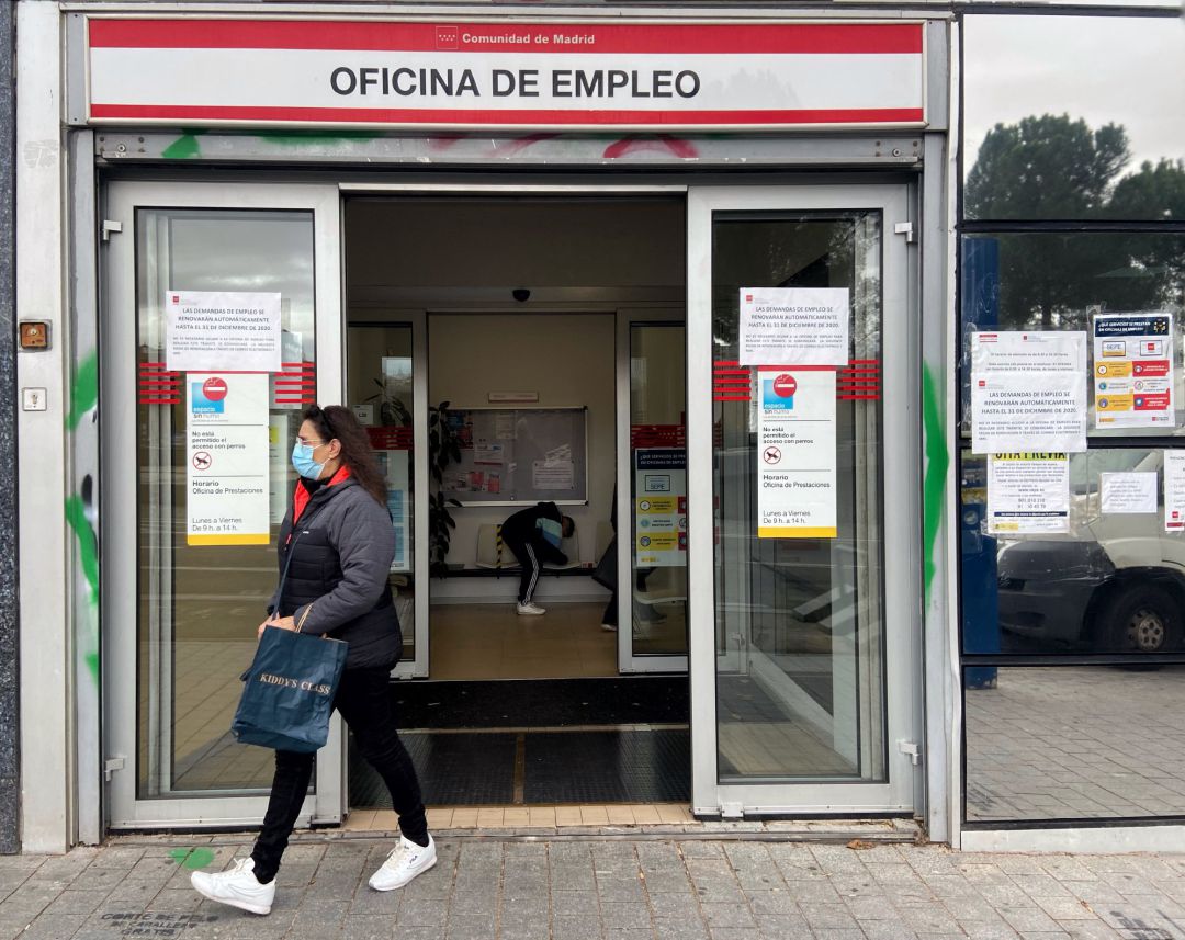 Una mujer sale de una oficina de empleo Una mujer sale de una oficina de empleo